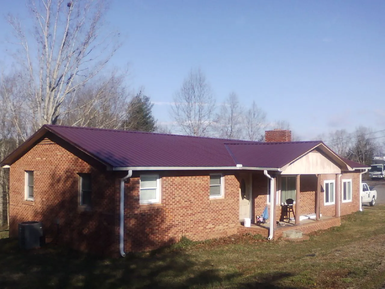 Burgundy metal roof on a brick ranch home with a new addition in Rural Valley