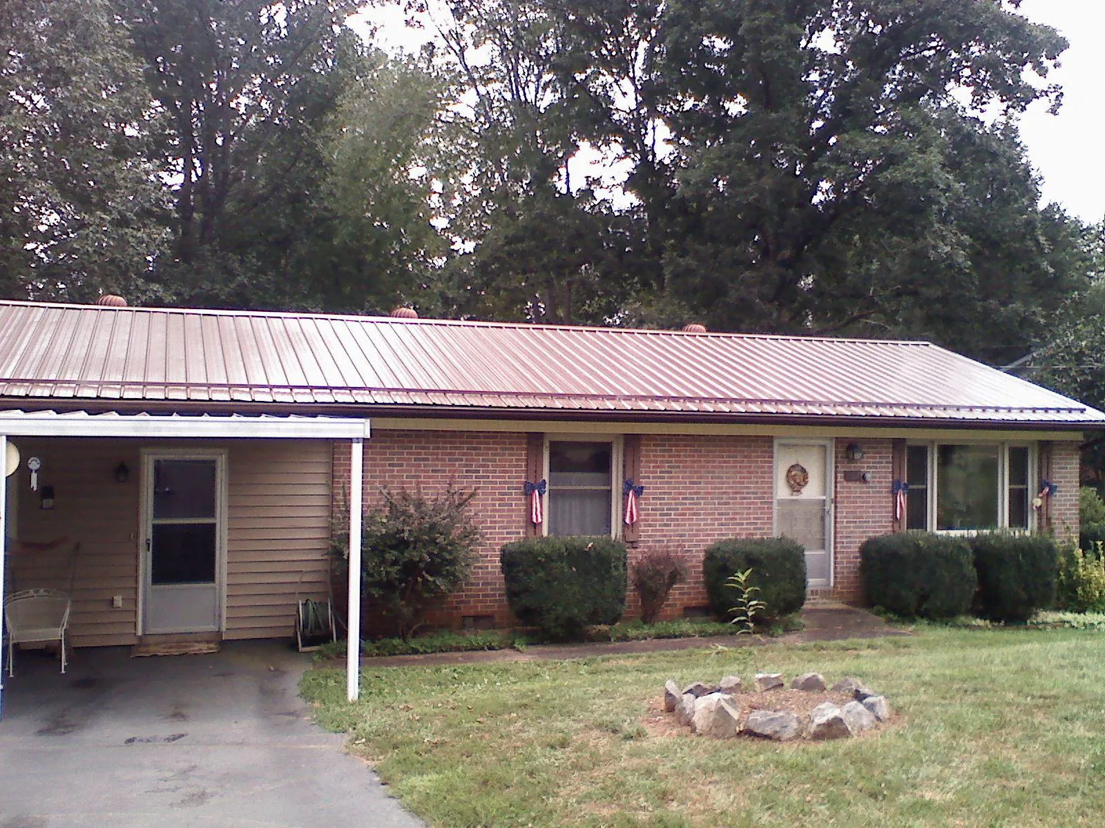 Bronze metal roof and carport on a brick ranch home — Roof Repair work by our crew in Rural Valley